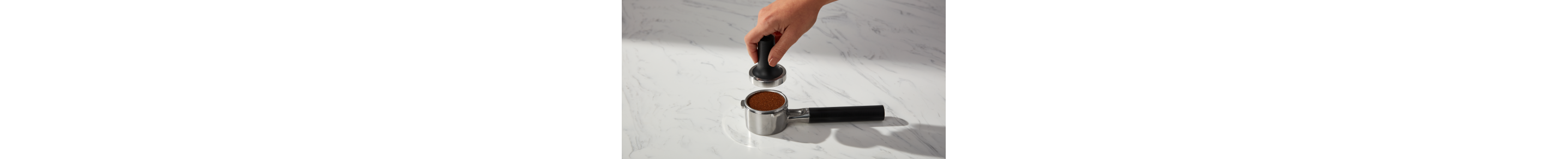 Person tamping espresso in a portafilter