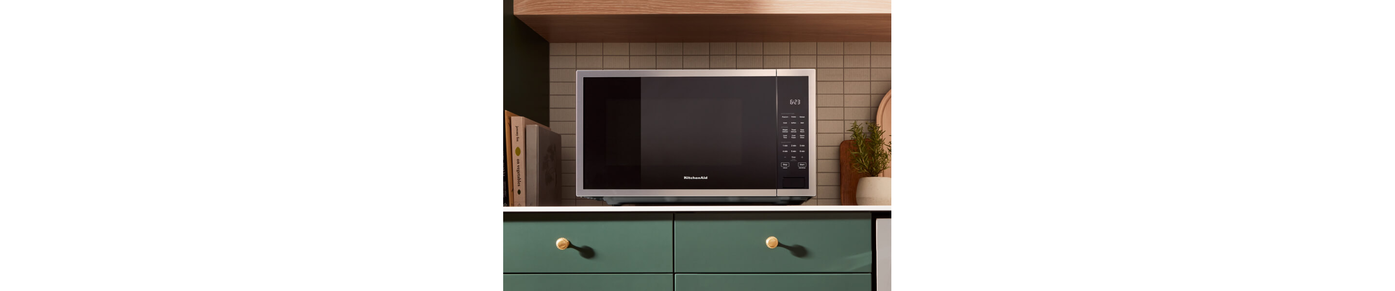 KitchenAid® countertop microwave above green cabinetry 