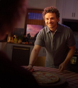 A person cutting a pizza.