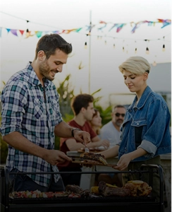 A person placing grilled meat on another person's plate.