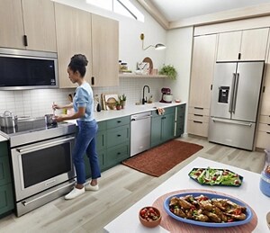 A person cooking in a kitchen with KitchenAid® appliances.