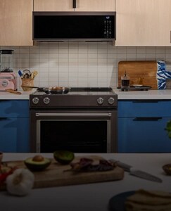 A kitchen with blue cabinets and KitchenAid® appliances.