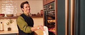 Chef Antoni Porowski removing a pan from a KitchenAid® wall oven