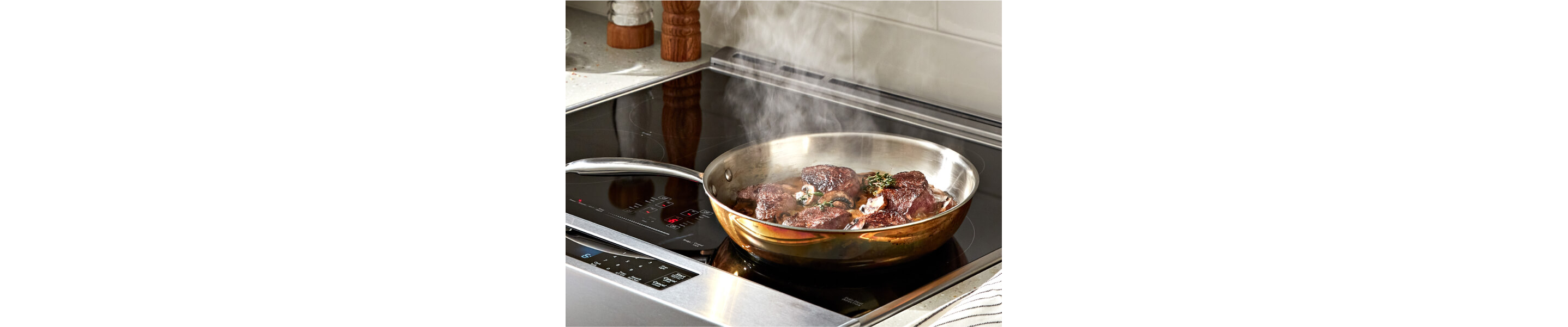 Ribeye steak cooking on a KitchenAid® cooktop