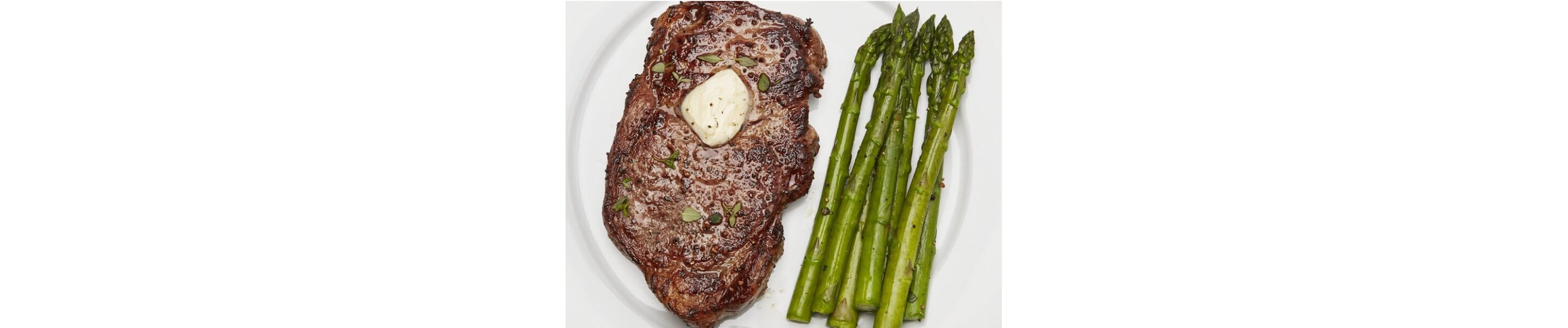 Juicy sirloin steak with a pad of butter and asparagus