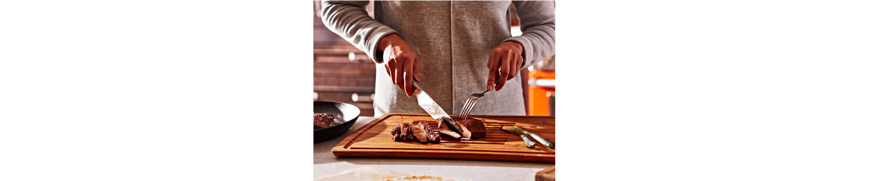 Person slicing a steak in their kitchen