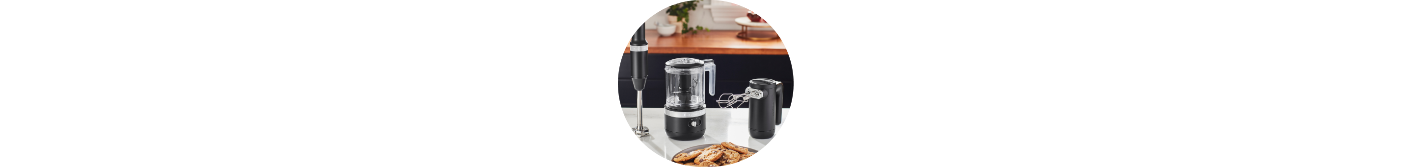 Onyx Black KitchenAid® Cordless Immersion Blender, Food Chopper, and Hand Mixer on white countertop.
