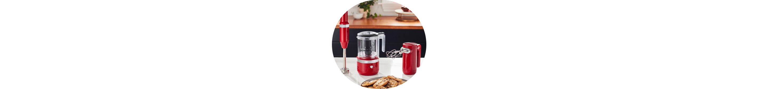 Empire Red KitchenAid® Cordless Immersion Blender, Food Chopper, and Hand Mixer on white countertop.
