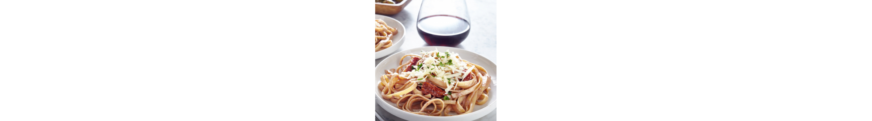 Fettuccine with meat sauce topped with shredded cheese