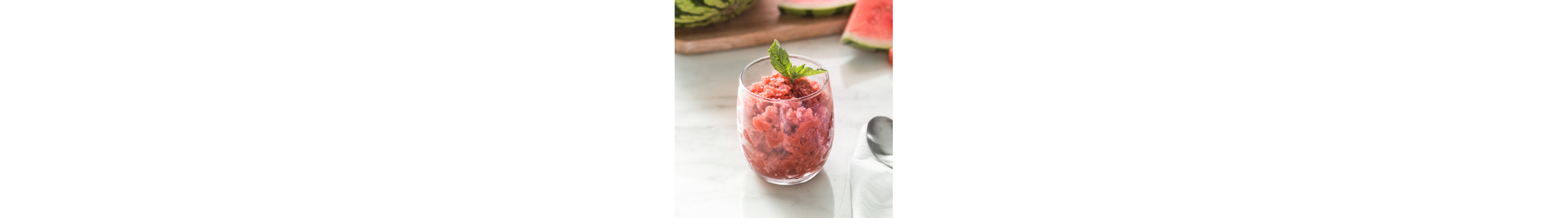 Shaved ice dessert garnished with fruit and mint