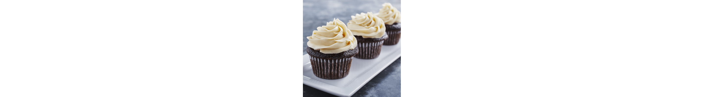 Three chocolate cupcakes topped with cream cheese frosting