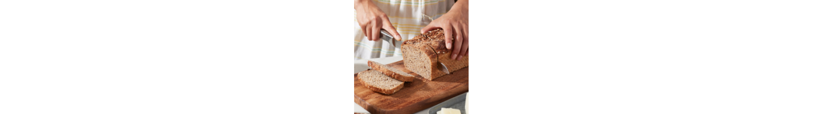 Person slicing homemade sandwich bread