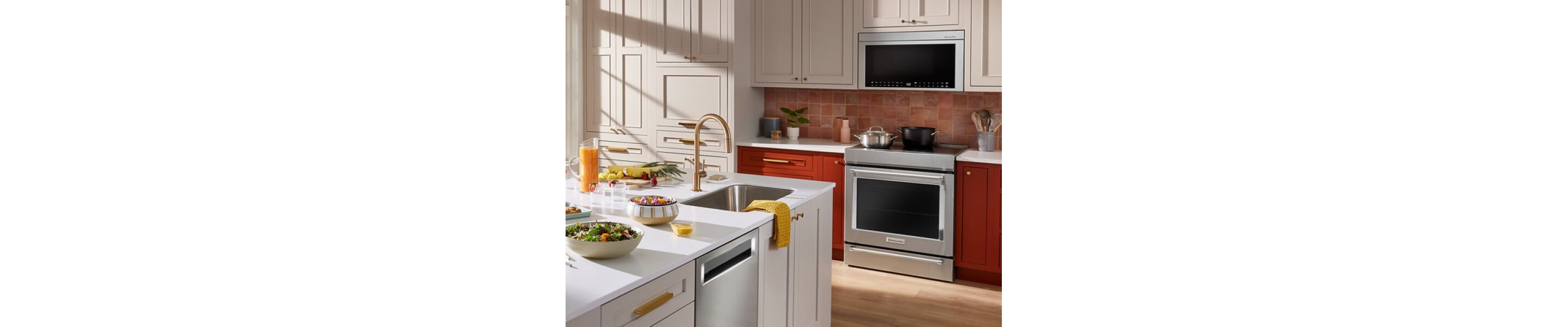Stainless steel KitchenAid® electric range beneath a KitchenAid® over-the-range microwave