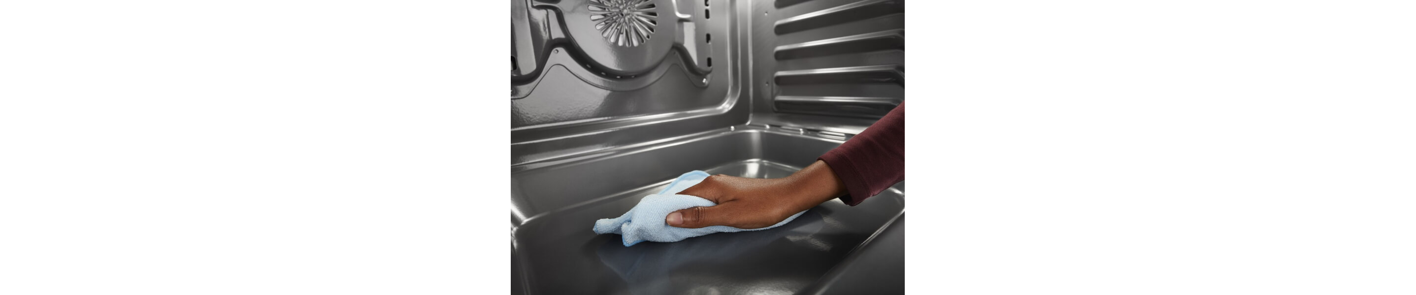 Person wiping down the inside of an oven
