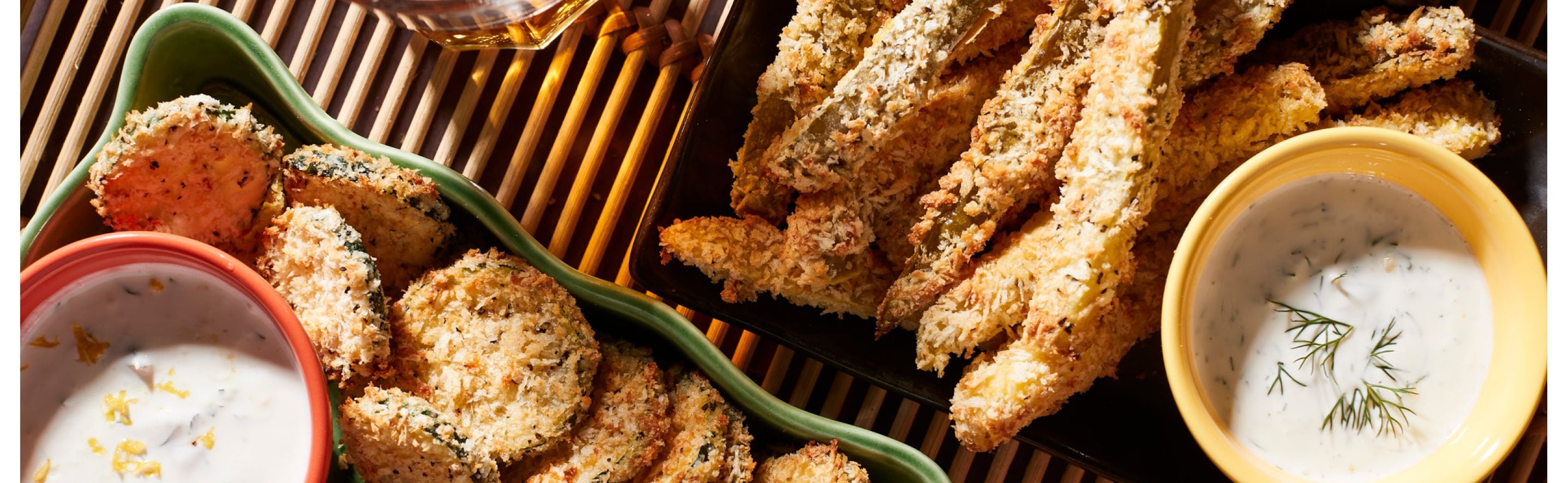 Assorted air-fried vegetables on and dipping sauce on tray.