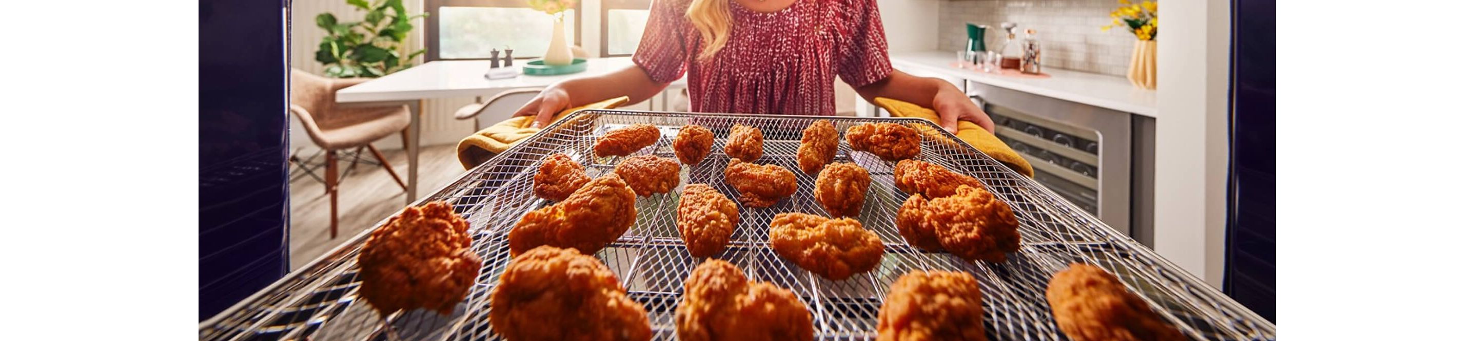 Person removing fried chicken from an air fryer