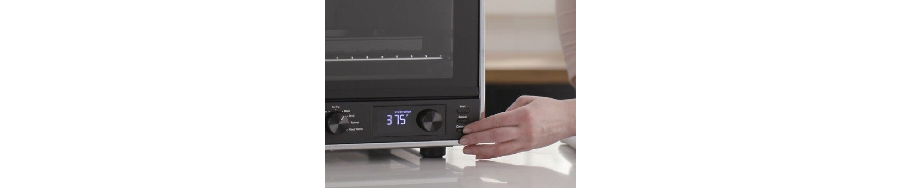 Person selecting a setting on a countertop oven