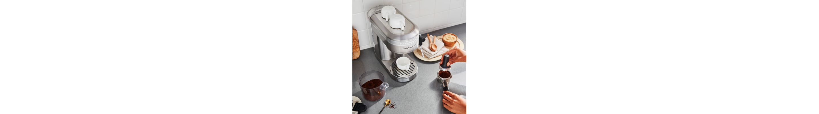 Stainless steel KitchenAid® espresso maker on a gray countertop