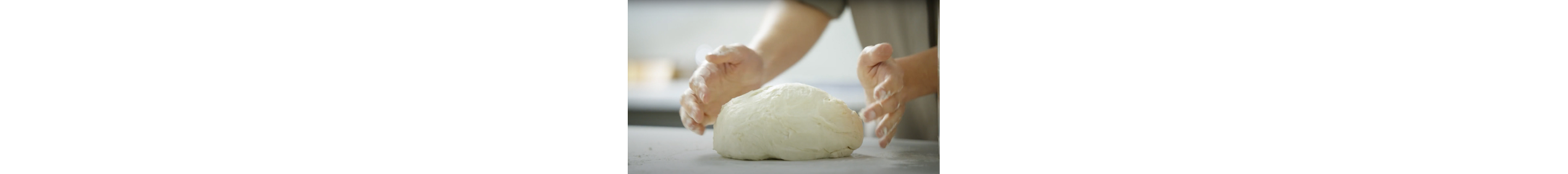 A person forming a mound of dough.