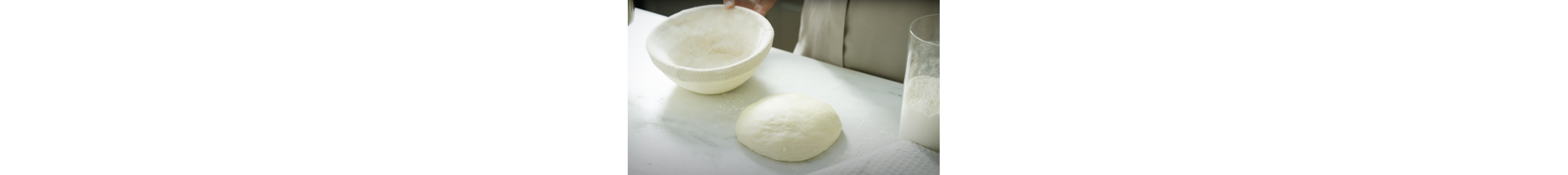 Rising dough and an empty proofing basket.