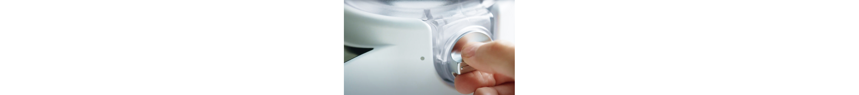 A person turning the dial on a KitchenAid® stand mixer attachment.