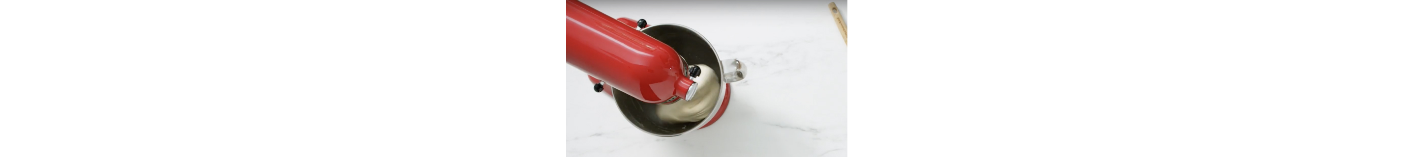 Dough being stirred in a stand mixer bowl.