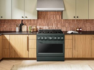 Juniper KitchenAid® Gas Range in front of vertical brick-colored backsplash