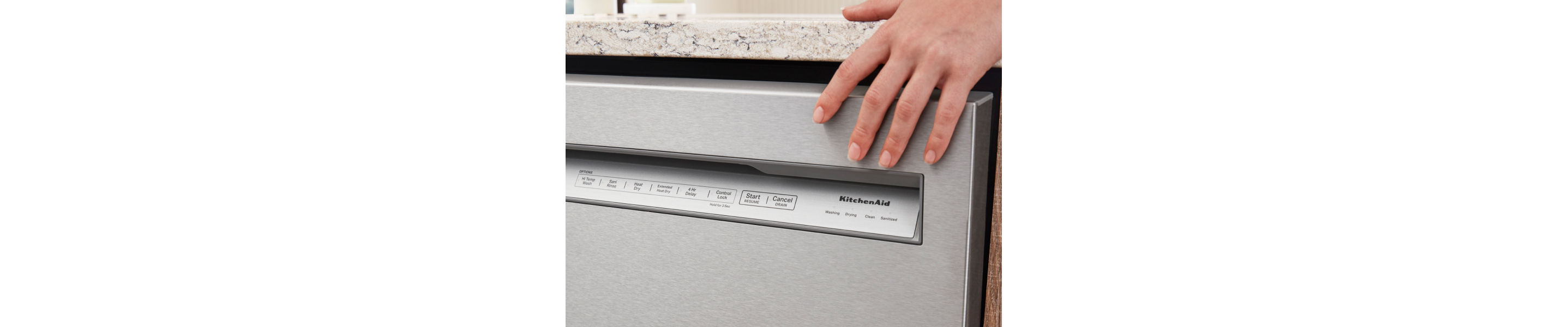 Hand touching a stainless steel KitchenAid® front control dishwasher