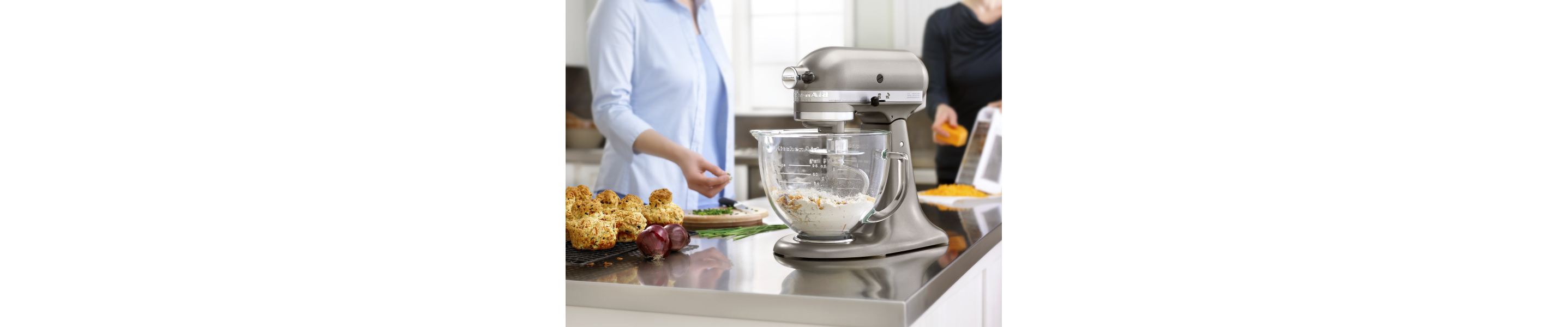 Ingredients mixing in the glass bowl of a silver stand mixer