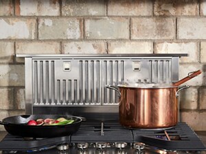 KitchenAid® Retractable Downdraft Ventilation System behind a gas cooktop