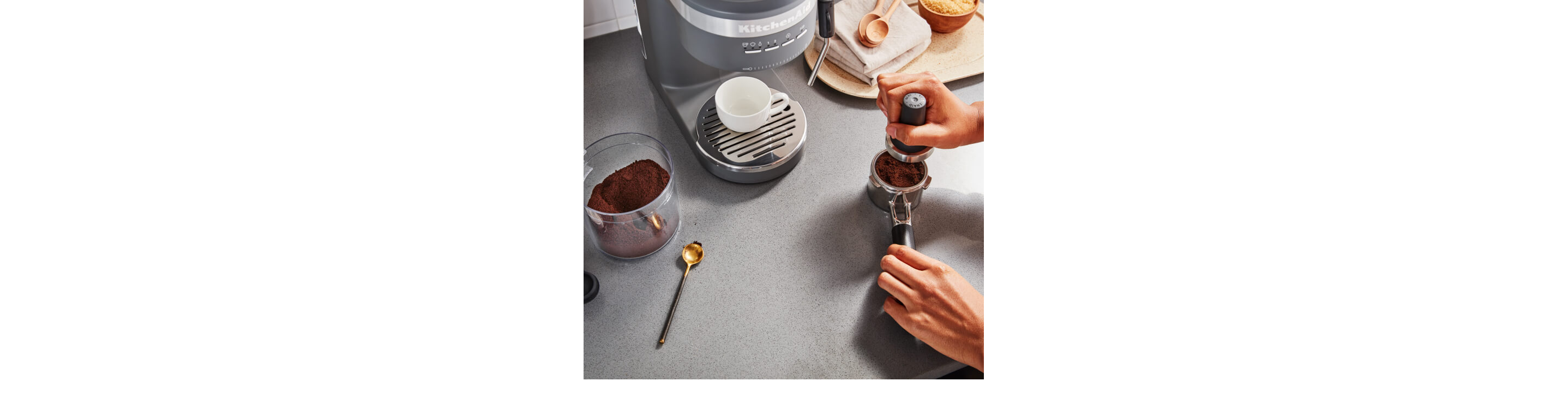 Person tamping coffee in an espresso machine portafilter