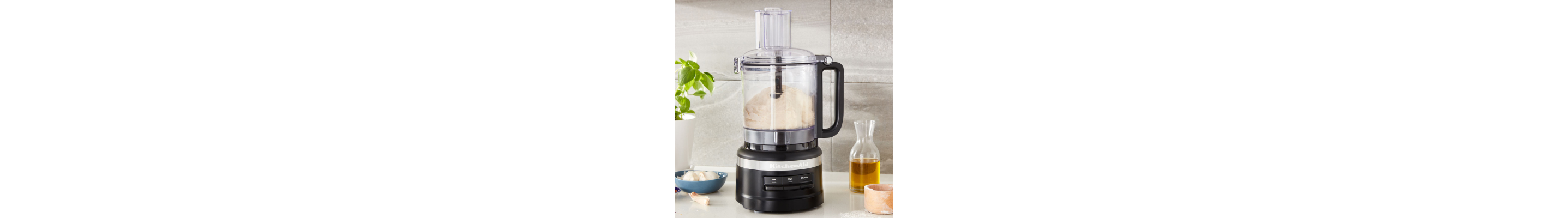 A KitchenAid® food processor with flour in the bowl.