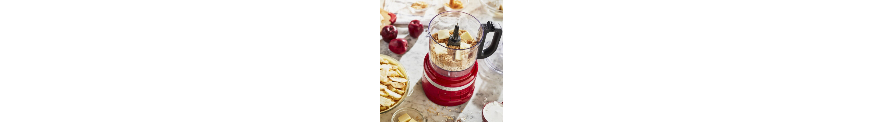 A KitchenAid® food processor with flour and butter in the bowl.