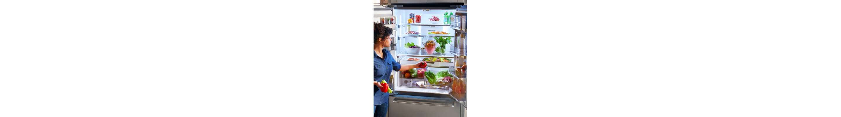 Person loading produce inside a French door refrigerator