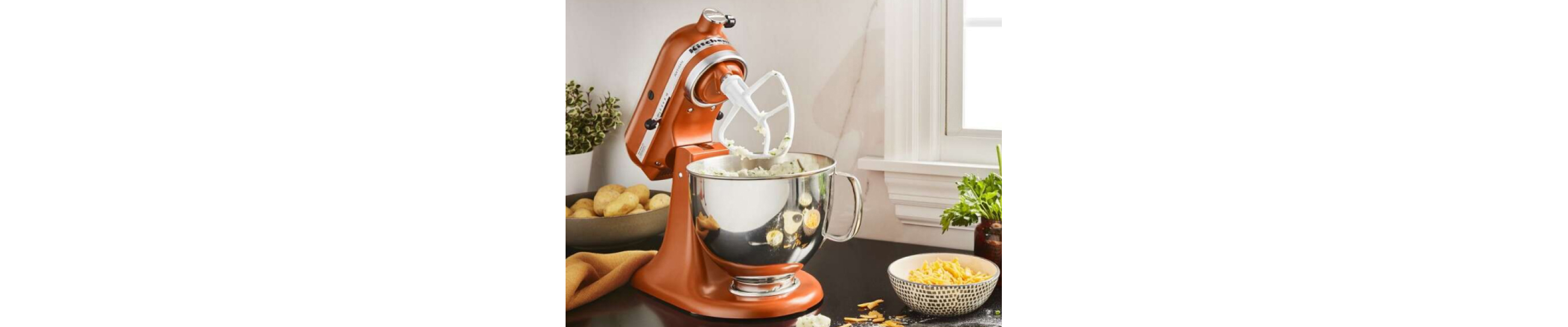 Orange KitchenAid® stand mixer with flat beater whipping mashed potatoes