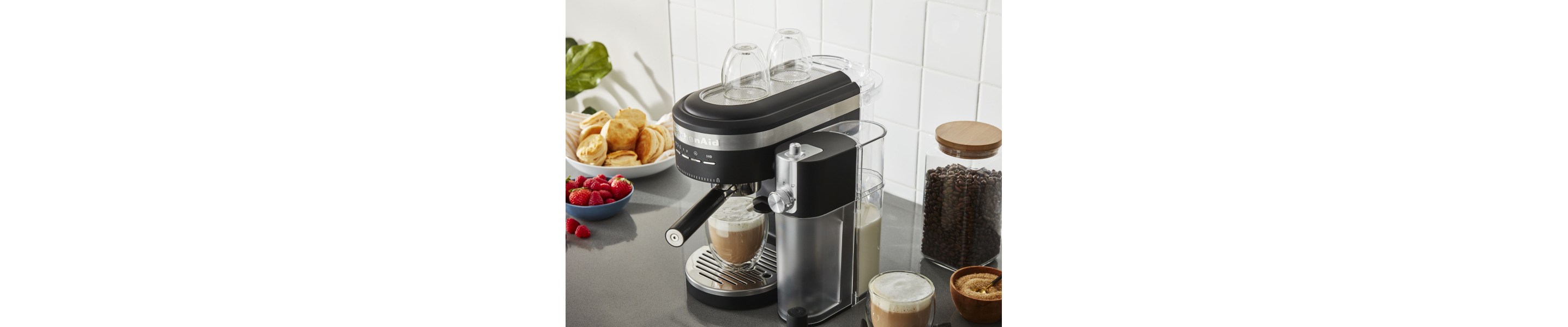 KitchenAid® espresso machine with the Milk Frother Attachment on counter with breakfast foods and latte