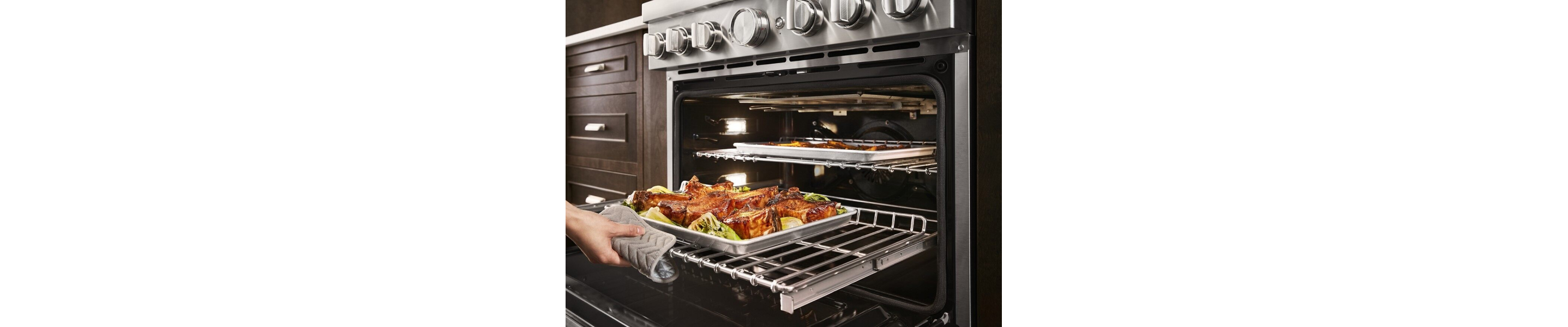 Roasted meats and vegetables being removed from oven