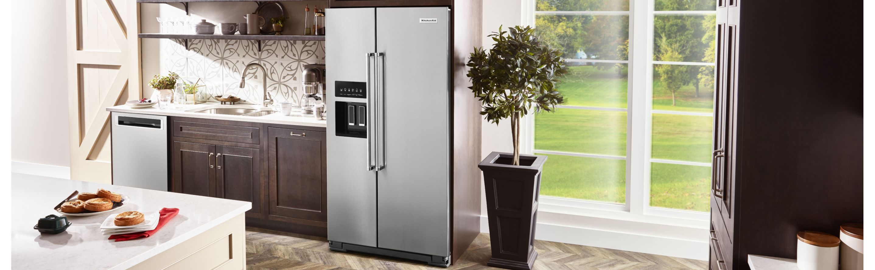 KitchenAid® side-by-side refrigerator in brown cabinetry 