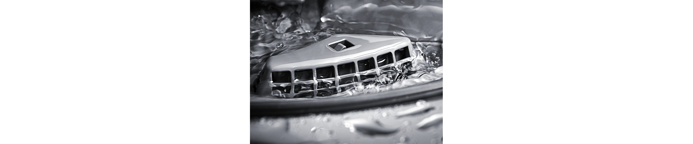 The interior of a KitchenAid® dishwasher releasing water.