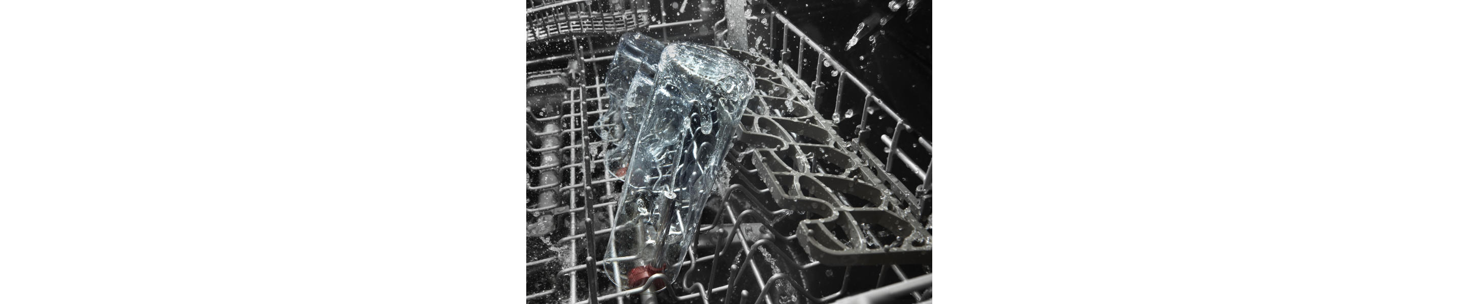 The top rack of a KitchenAid® dishwasher during a wash cycle.