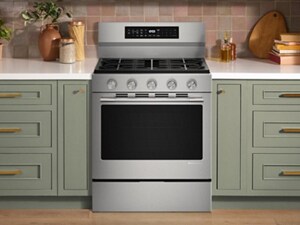 A gas range in a bright kitchen with white countertops