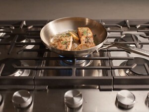 Food cooking in a pan on a gas cooktop