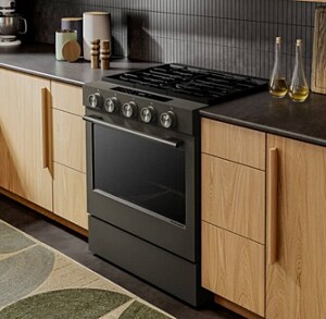 A kitchen with a warm feel, gas stove, and dark countertops