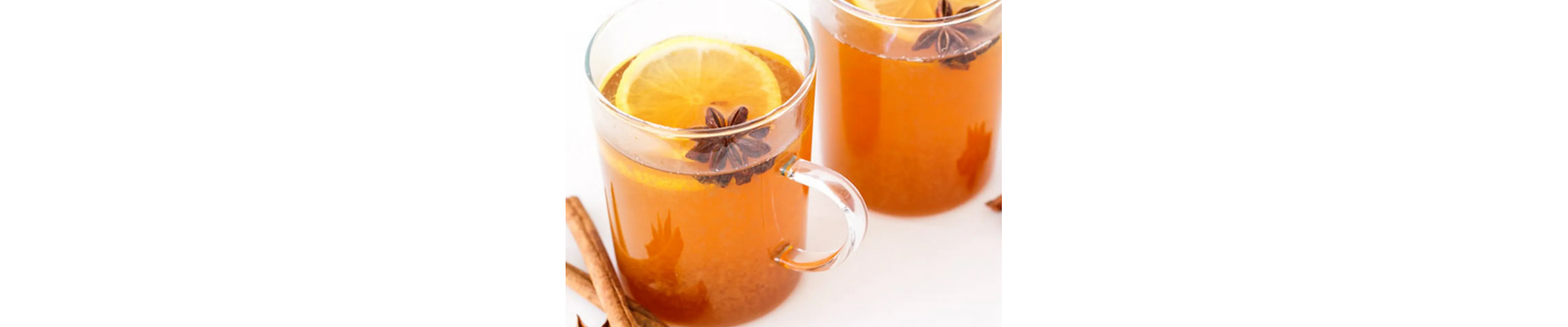 Two glass mugs of black tea with lemon and spices
