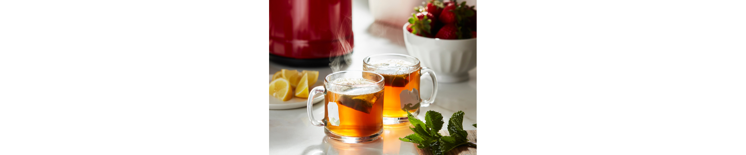 Two glass mugs steeping oolong tea bags