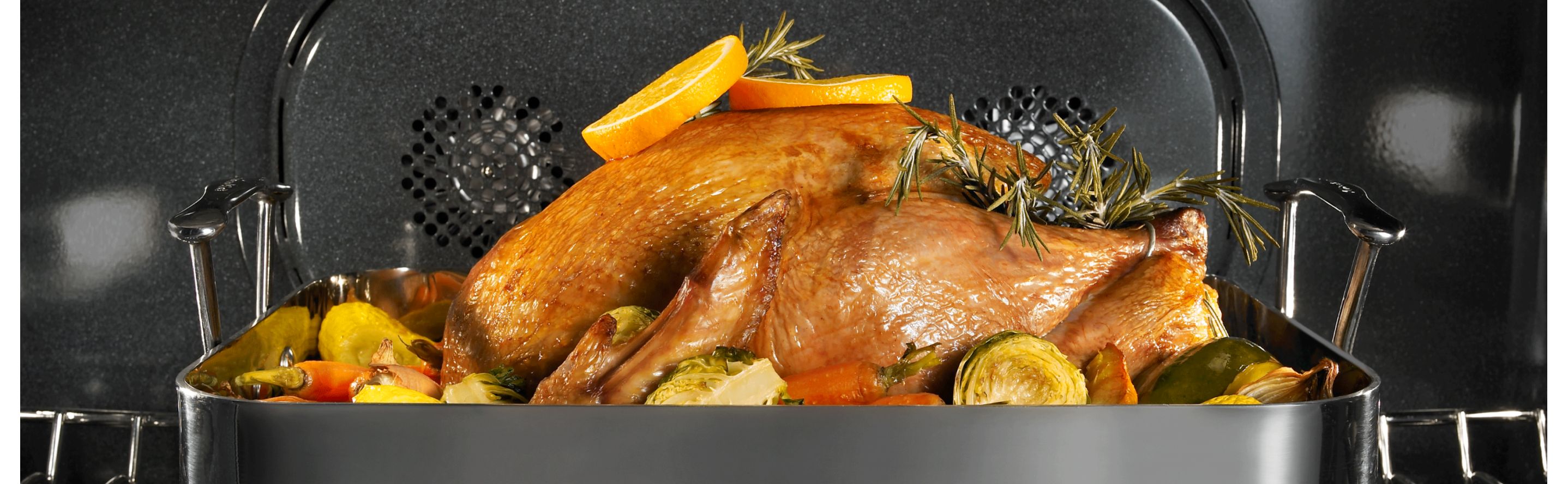 Full turkey in an oven seasoned with herbs and vegetables