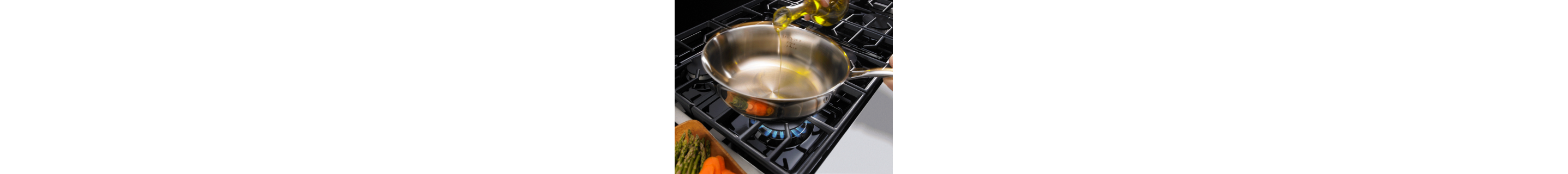 Bottle of oil being poured into a pan on a cooktop