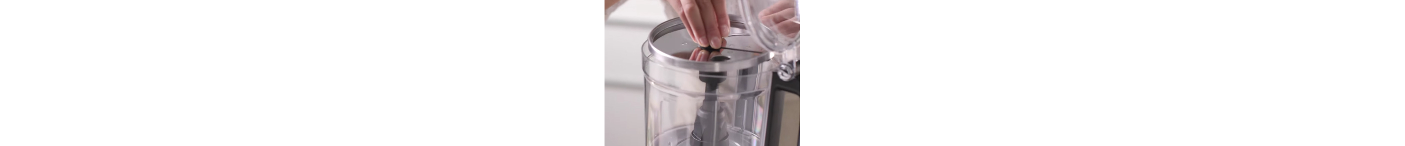 A user opening a food processor and adding blade.