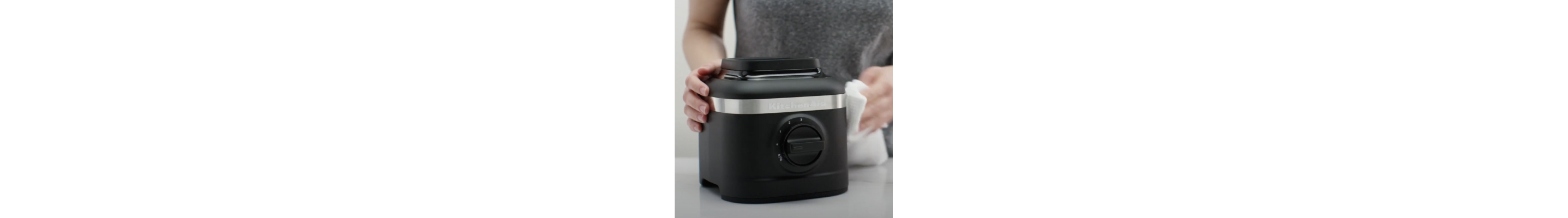 Person cleaning black KitchenAid® blender base