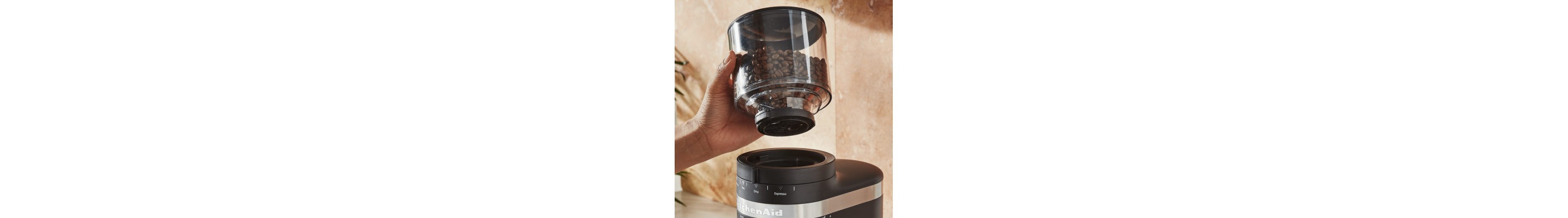 Hand removing a bean hopper from a burr grinder